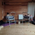 femmes enceinte en posture de yoga sur chaise pour se relaxer